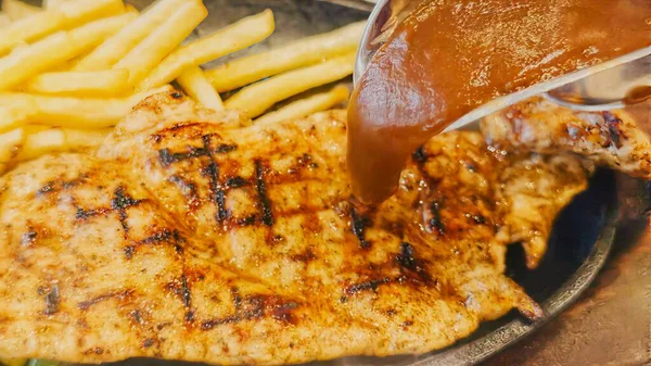 Kızarmış patates kızartması ve renkli taze sebzelerle servis edilen sulu ızgara tavuk bifteği restoran menüsü, yemek reklamı ve ticari mutfak içeriği için mükemmel.