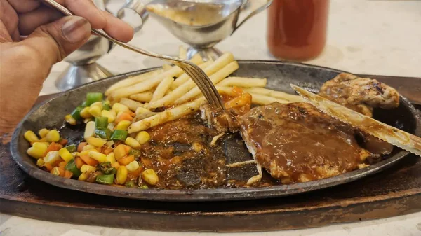 Kızarmış patates kızartması ve renkli taze sebzelerle servis edilen sulu ızgara tavuk bifteği restoran menüsü, yemek reklamı ve ticari mutfak içeriği için mükemmel.