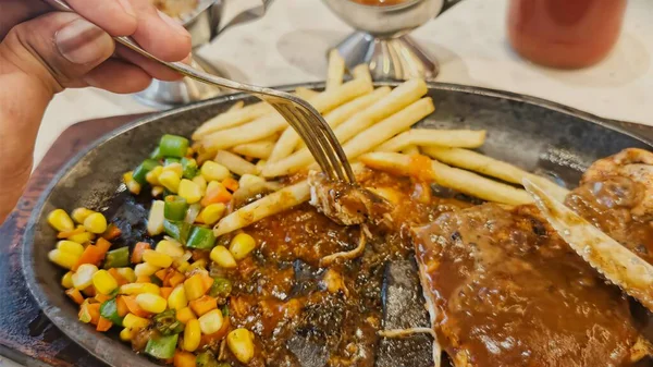 Kızarmış patates kızartması ve renkli taze sebzelerle servis edilen sulu ızgara tavuk bifteği restoran menüsü, yemek reklamı ve ticari mutfak içeriği için mükemmel.