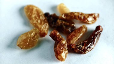 Kuru üzümler, beyaz arka planda sağlıklı doğal çerez konsepti için izole edilmiş, parlak dokuyu, zengin rengi ve gıda reklamcılığı, besin içeriği ve ticari kullanım için ideal organik görünüşü vurguluyor..