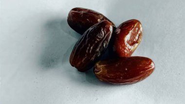 Taze tarihler, sağlıklı doğal çerez konsepti için beyaz arka planda izole edilmiş beyaz meyveler, parlak dokular ve gıda reklamları için mükemmel kahverengi renkler, beslenme içeriği ve ticari kullanım için mükemmel..