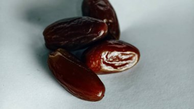 Taze tarihler, sağlıklı doğal çerez konsepti için beyaz arka planda izole edilmiş beyaz meyveler, parlak dokular ve gıda reklamları için mükemmel kahverengi renkler, beslenme içeriği ve ticari kullanım için mükemmel..