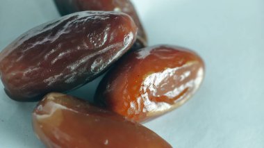 Taze tarihler, sağlıklı doğal çerez konsepti için beyaz arka planda izole edilmiş beyaz meyveler, parlak dokular ve gıda reklamları için mükemmel kahverengi renkler, beslenme içeriği ve ticari kullanım için mükemmel..