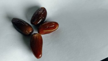 Taze tarihler, sağlıklı doğal çerez konsepti için beyaz arka planda izole edilmiş beyaz meyveler, parlak dokular ve gıda reklamları için mükemmel kahverengi renkler, beslenme içeriği ve ticari kullanım için mükemmel..