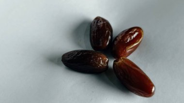 Taze tarihler, sağlıklı doğal çerez konsepti için beyaz arka planda izole edilmiş beyaz meyveler, parlak dokular ve gıda reklamları için mükemmel kahverengi renkler, beslenme içeriği ve ticari kullanım için mükemmel..