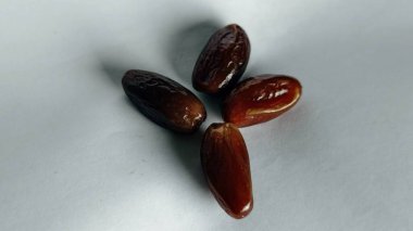 Taze tarihler, sağlıklı doğal çerez konsepti için beyaz arka planda izole edilmiş beyaz meyveler, parlak dokular ve gıda reklamları için mükemmel kahverengi renkler, beslenme içeriği ve ticari kullanım için mükemmel..