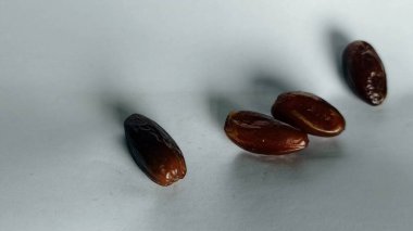 Taze tarihler, sağlıklı doğal çerez konsepti için beyaz arka planda izole edilmiş beyaz meyveler, parlak dokular ve gıda reklamları için mükemmel kahverengi renkler, beslenme içeriği ve ticari kullanım için mükemmel..