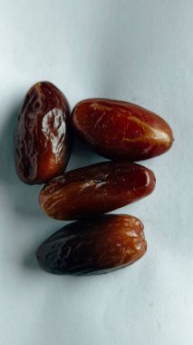 Taze tarihler, sağlıklı doğal çerez konsepti için beyaz arka planda izole edilmiş beyaz meyveler, parlak dokular ve gıda reklamları için mükemmel kahverengi renkler, beslenme içeriği ve ticari kullanım için mükemmel..