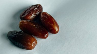 Taze tarihler, sağlıklı doğal çerez konsepti için beyaz arka planda izole edilmiş beyaz meyveler, parlak dokular ve gıda reklamları için mükemmel kahverengi renkler, beslenme içeriği ve ticari kullanım için mükemmel..