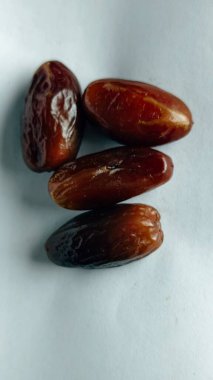 Taze tarihler, sağlıklı doğal çerez konsepti için beyaz arka planda izole edilmiş beyaz meyveler, parlak dokular ve gıda reklamları için mükemmel kahverengi renkler, beslenme içeriği ve ticari kullanım için mükemmel..