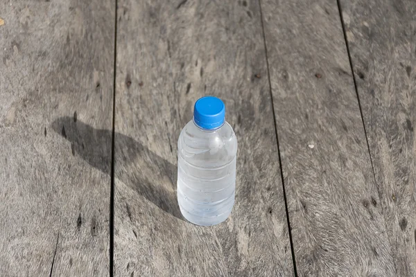 Garrafa de água de plástico na textura da mesa de madeira . — Fotografia de Stock
