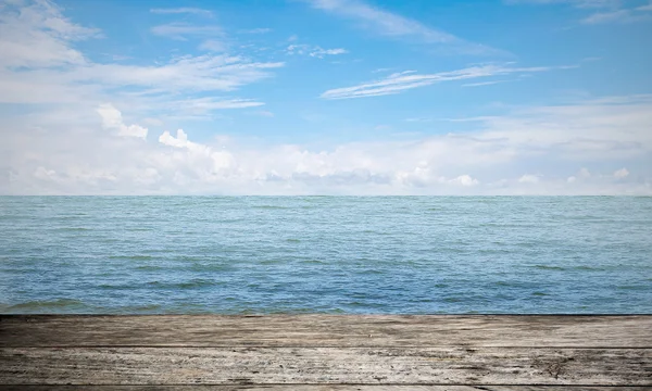 青い空を背景に海の横にある空の木の床. — ストック写真