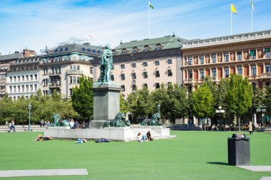 Stockholm, İsveç - 1 Eylül 2016. İnsanlar Karl XII Merkezi Stockholm alan Kungstradgarden, Stockholm, İsveç Kralı'nın Garden'da üzerinde Anıtı, suni çim dinlenin