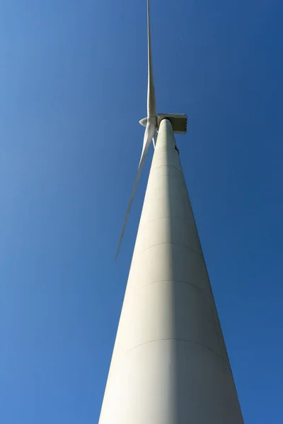 View from below of wind and renewable energy masts with their large propellers and turbines in a rural area in the north of Spain. Alternative and renewable energy concept. — Stock Photo, Image