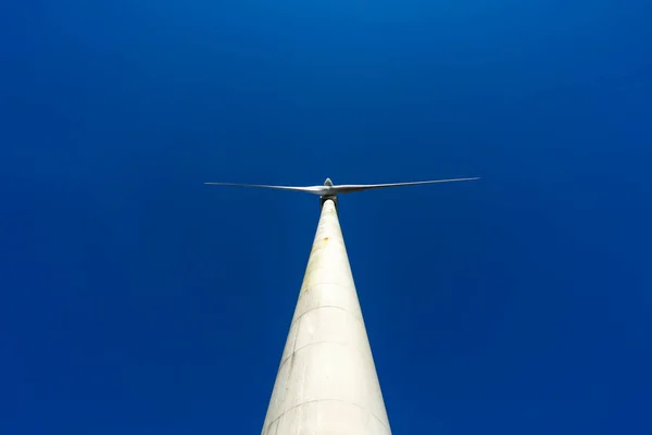 Rüzgarın ve yenilenebilir enerji direklerinin altından İspanya 'nın kuzeyindeki kırsal bir bölgede geniş pervane ve türbinlerinin görüntüsünü alıyoruz. Alternatif ve yenilenebilir enerji kavramı. 