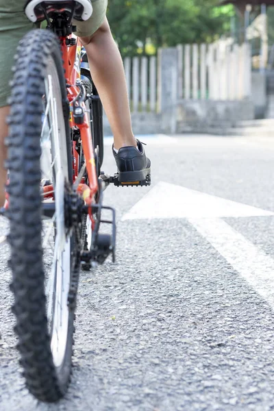 Bisikletinin üzerine monte edilmiş bir çocuğun bacaklarının üzerine, yere boyanmış beyaz bir ok işaretinin yanına oturmaya hazır bir şekilde yaklaş. Kavram İlerlemeye devam et — Stok fotoğraf