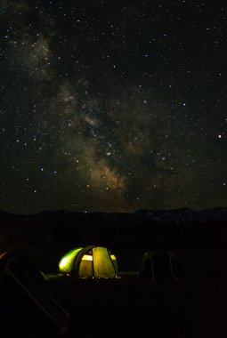 Gece dağ manzarası ile çadır ve karlı dağ zirveleri ve 