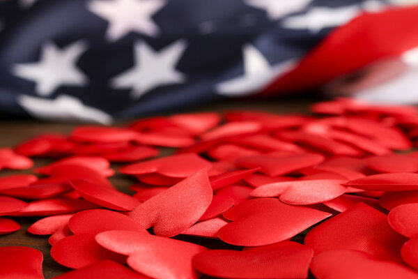Навалочные красные сердца и флаг США, на деревянном столе.Вид сверху. Празднование, любовь, патриотизм.
.