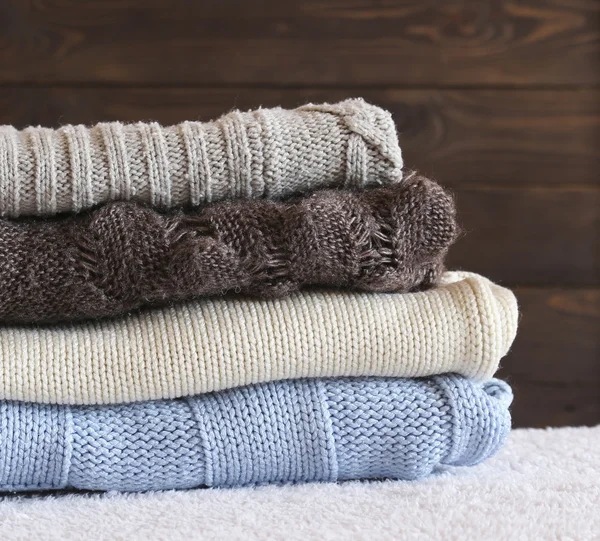 Pila de suéter cálido de punto acogedor en el fondo de su casa  . —  Fotos de Stock