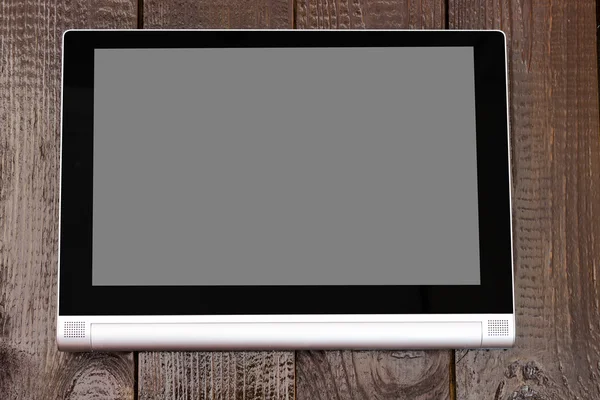 Tablet with isolated screen on the brown wooden table. — Stock Photo, Image