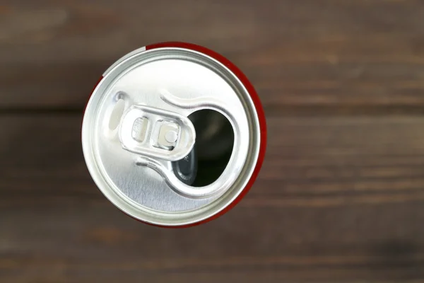 Crumpled empty blank soda or beer trash on the old ten wooden background.Crumpled aluminum can. Jar red.