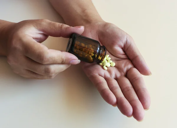 Una joven vierte las pastillas del frasco. . — Foto de Stock