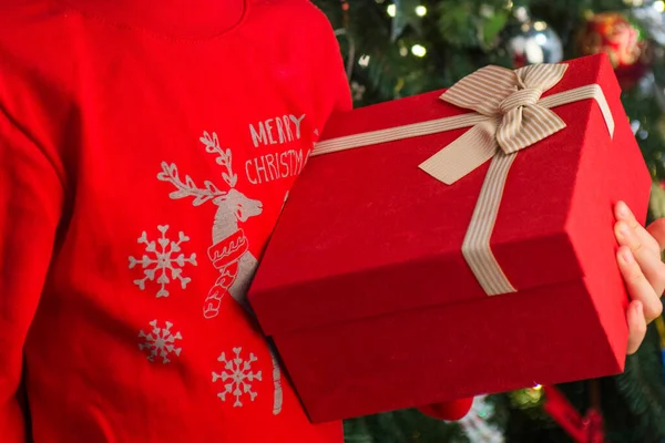 带着圣诞礼物坐在圣诞树旁的小孩 小孩手里拿着礼品盒 新年快乐 圣诞节的概念 — 图库照片