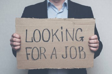 Karantina yüzünden işini kaybeden genç bir işadamı iş arıyor. Bir işadamı, iş arayan bir karton tabela tutuyor. İşsizlik büyümesi kavramı