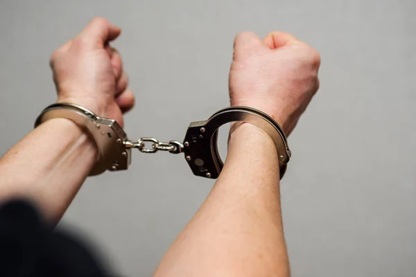 Elleri kelepçeli. Tutuklu ya da tutuklu, elleri kelepçeli. Elleri kelepçeli erkek eller.