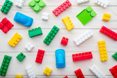 Renkli plastik oyuncak blokları. Beyaz tahta arka planda renkli plastik oyuncak blokları. Üst Manzara. Bebek arka planı