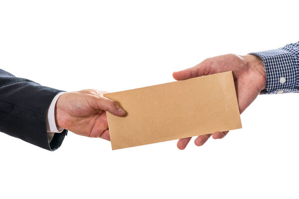 Человек, дающий взятки в коричневом конверте другому бизнесмену в мошенничестве с коррупцией. Закрытие рук, дающих конверт с взяткой изолированы на белом фоне.