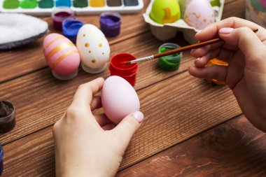 Püsküllü bir kadın Paskalya yumurtalarını boyuyor. Paskalya için dekorasyon hazırlamak, çocuklarla yaratıcılık, geleneksel semboller. Paskalya için hazırlanılıyor.