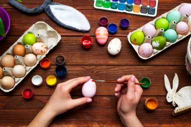 Püsküllü bir kadın Paskalya yumurtalarını boyuyor. Paskalya için dekorasyon hazırlamak, çocuklarla yaratıcılık, geleneksel semboller. Paskalya için hazırlanılıyor.