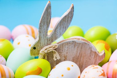 Renkli Paskalya yumurtaları ve tahta tavşan. Paskalya yumurtalarının arasında sevimli bir tavşan.