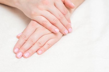 Havlu üzerindeki güzel kadın ellerinin yakın görüntüsü. Havlu üzerindeki güzel kadın elleri. El bakımı. Kadınlar ellerindeki çivileri önemser. El derisi ile güzellik tedavisi.