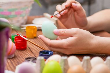 Püsküllü bir kadın Paskalya yumurtalarını boyuyor. Paskalya için dekorasyon hazırlamak, çocuklarla yaratıcılık, geleneksel semboller. Paskalya için hazırlanılıyor.