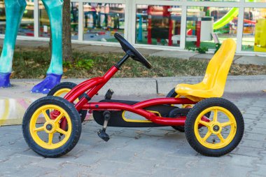 Four wheeled bicycle on pavement on the park. Children pedal karting.