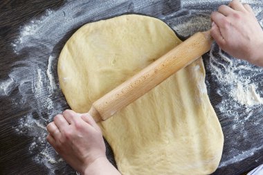 Eller, merdane ve hamur ekmek, makarna ya da ahşap masada pizza. Merdane kullanarak para kazanma süreci.