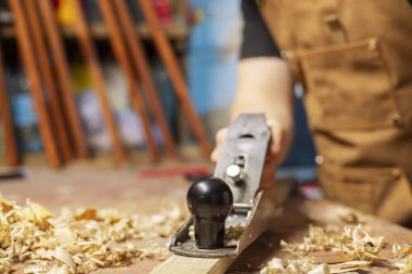 Marangoz önlüklü, ahşap bir tahta ve bir işyeri..