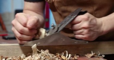 Marangoz önlüklü, ahşap bir tahta ve bir işyeri.