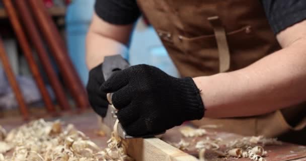 Timmerman Een Schort Schaaft Een Houten Plank Met Een Schaafmachine — Stockvideo