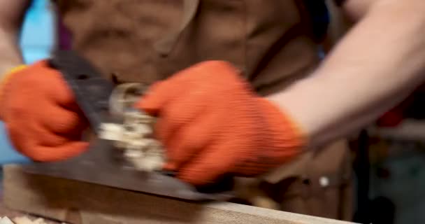在围裙上的木匠用刨床在木板上刨花 工作场所 — 图库视频影像