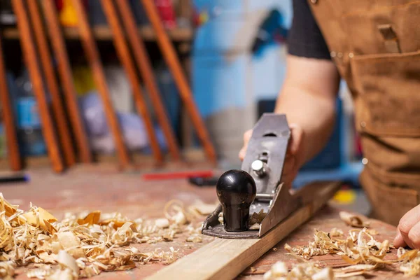 Marangoz önlüklü, ahşap bir tahta ve bir işyeri..
