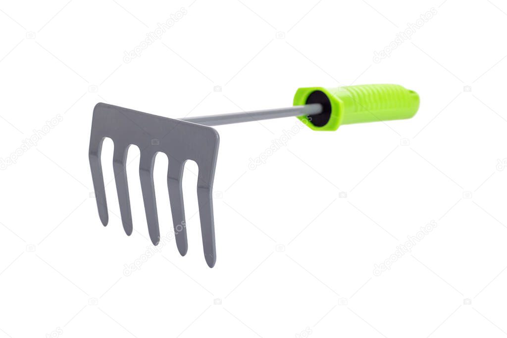 Small garden rake with green plastic handle isolated on a white background.