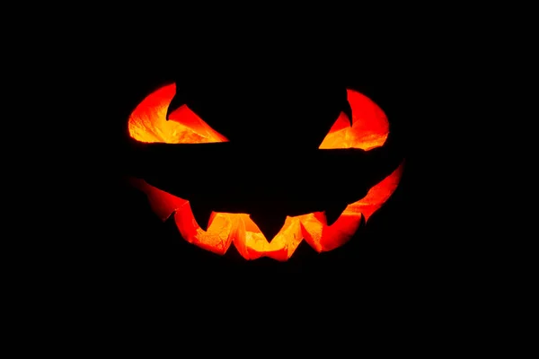 Glowing eyes and mouth of halloween pumpkin (Jack o lantern) on black background. Halloween.