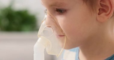 Küçük bir çocuk solunum terapisi için nebulizör maskesi kullanır. Video, çocuğun ilaçlarını solumasını, ev sağlık hizmetlerini ve pediatrik solunum hizmetlerini ön plana çıkarıyor..