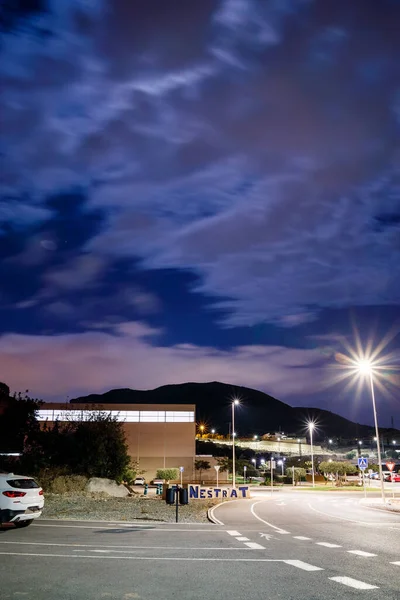 Finestrat, Alicante, İspanya. 18-12-2021. Finestrat 'ın içine veya yakınına giden yolun dikey gece çekimi,' FINESTRAT 'tabelasının ve aydınlanmış yol kenarının kısmi bir görüntüsü. 