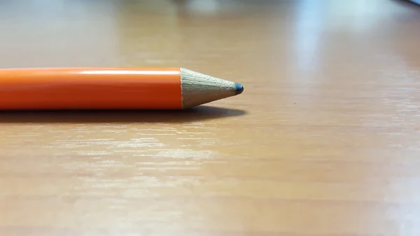 Ahşap masa üzerinde turuncu kalem. — Stok fotoğraf