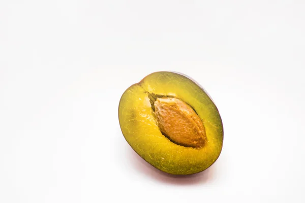 Plum half with a stone on a white background — Stock Photo, Image