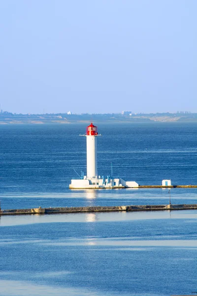 Vit fyr i det blå havet — Stockfoto